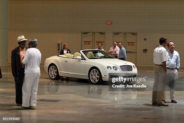 People check out a 2009 Bentley Continental GTC before the auction put on by Rick Levin and Associates, Inc., on behalf of the U.S. Dept. Of the...