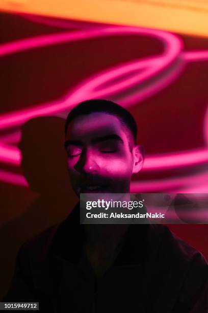 young man illuminated by neon lights - strip lights stock pictures, royalty-free photos & images