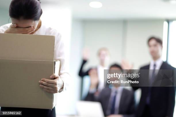 businesswoman carrying box of belongings,colleagues in background - rejection fotografías e imágenes de stock