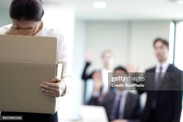 businesswoman carrying box of belongings,colleagues in background - recusando - fotografias e filmes do acervo