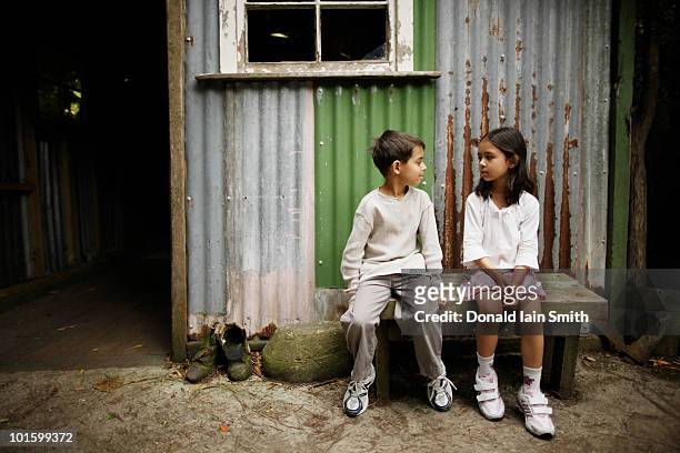 sitting by the shed - pakistani boys stockfoto's en -beelden
