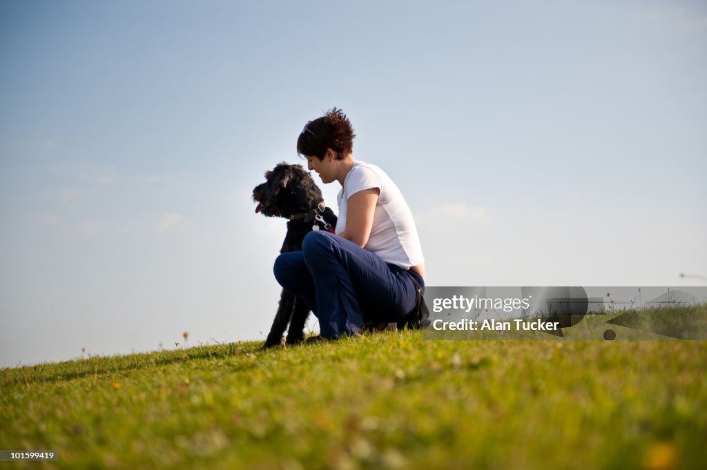 Girl Sat With Dog On Hill