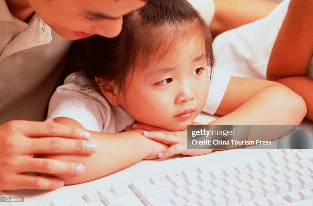FATHER TEACHING DAUGHTER USING COMPUTER
