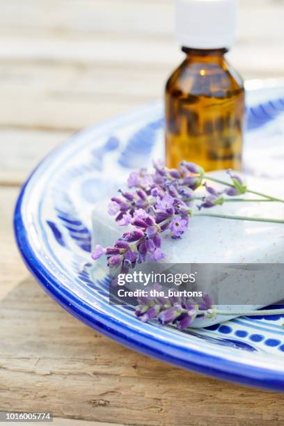 still life of a plate with lavender, soap and bottle of aromatherapy oil on wooden table - lavender colored stock pictures, royalty-free photos & images