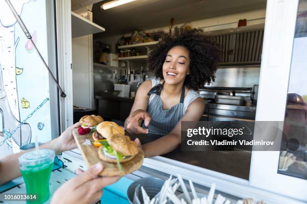 african woman vending burgers and sandwiches - food truck festival stock pictures, royalty-free photos & images