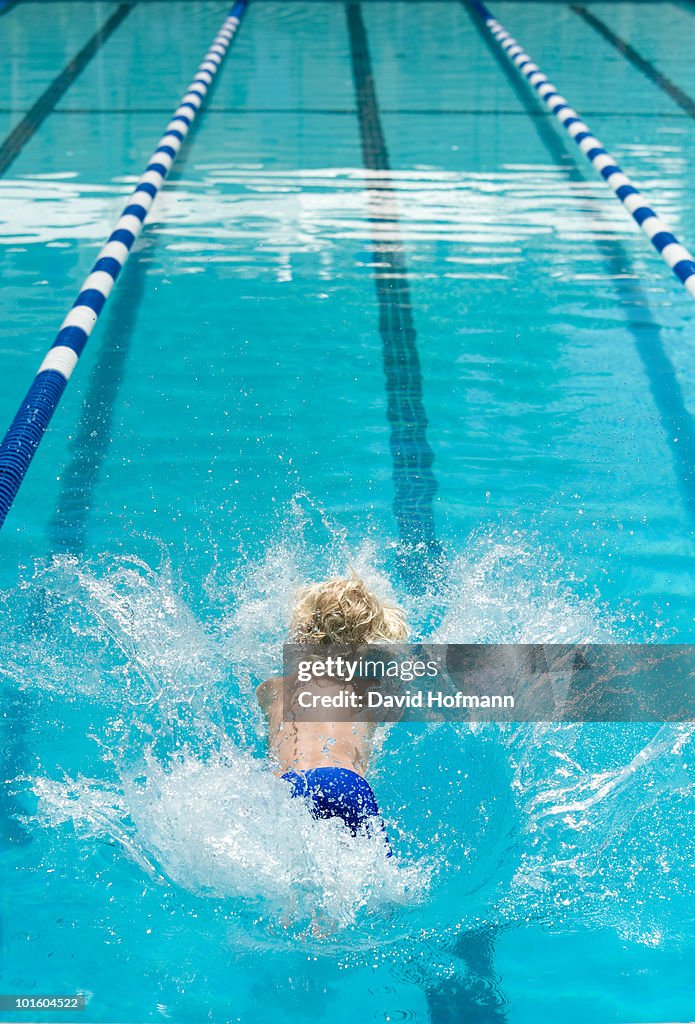 Boy jumping into a swimming pool