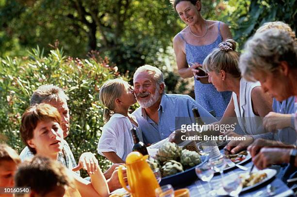 girl kisses grandpa at family barbecue table - 家族の集まり ストックフォトと画像