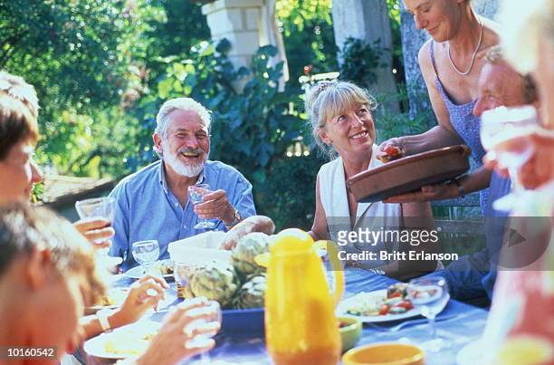40-60 year olds eating outside at table - 40 year old man stockfoto's en -beelden