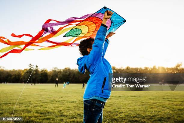 young boy learning to fly kite - flying child stock-fotos und bilder