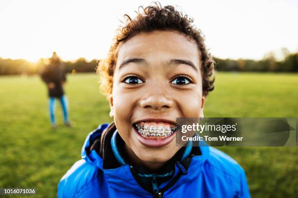 young boy smiling while spending time with dad - orthodontics fotografías e imágenes de stock