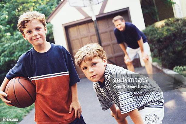 dad and twin boys on driveway, basketball - twin boys stock pictures, royalty-free photos & images