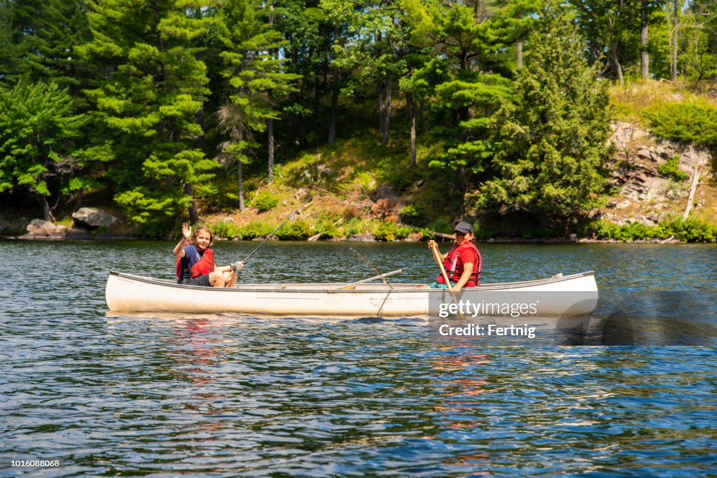 Two brothers fishing in a canoe on a beautiful northern lake