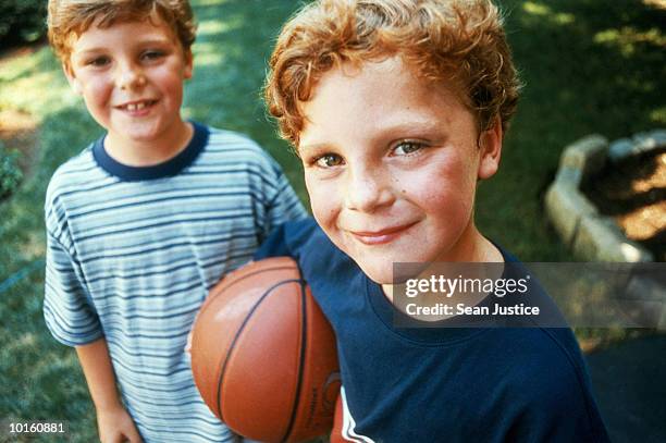 portrait of twin boys with basketball - twin boys stock pictures, royalty-free photos & images