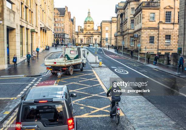 cycling among traffic in edinburgh - cycling scotland stock pictures, royalty-free photos & images