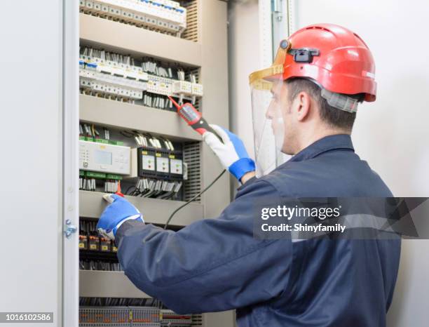 elektriker tests für spannung am terminal block - stromkasten stock-fotos und bilder
