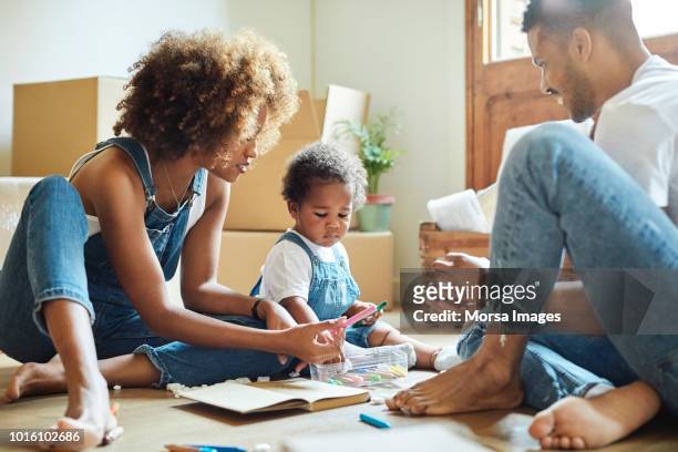 familie met kleurpotloden in nieuw huis - american family stockfoto's en -beelden