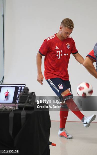 Joshua Kimmich of FC Bayern Muenchen kicks a ball in a photographer's set-up during the team presentation at Allianz Arena on August 13, 2018 in...