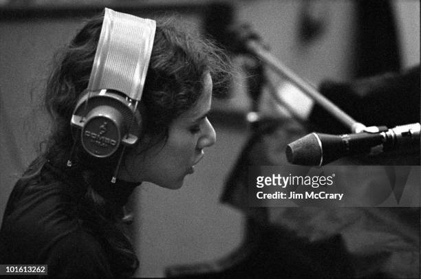 Singer-songwriter Carole King sings into a microphone wearing headphones during the recording of her album 'Tapestry' at A&M Records Recording Studio...