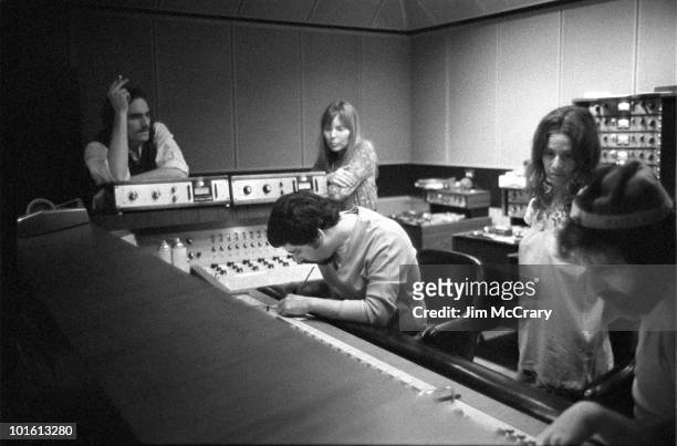 James Taylor, recording engineer Hank Cicalo, Joni Mitchell , Carole King and record producer Lou Adler gather around the mixing desk for a playback...