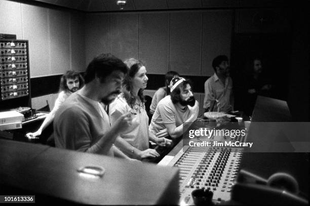 Recording engineer Hank Cicalo, Carole King and record producer Lou Adler gather around the mixing desk for a playback in the control room of A&M...