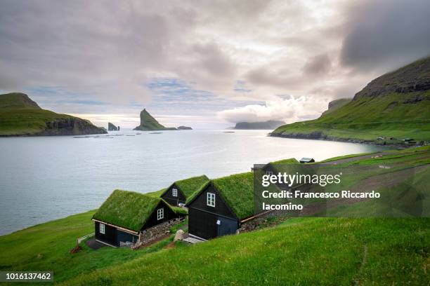 houses near the small village of bøur, with drangarnir and tindhólmur on background. faroe islands - faroe islands stock pictures, royalty-free photos & images