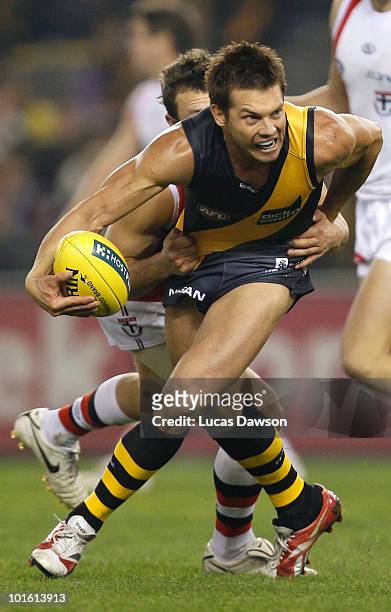 Ben Cousins of the Tigers is tackled during the round 11 AFL match between the Richmond Tigers and the St Kilda Saints at Etihad Stadium on June 4,...
