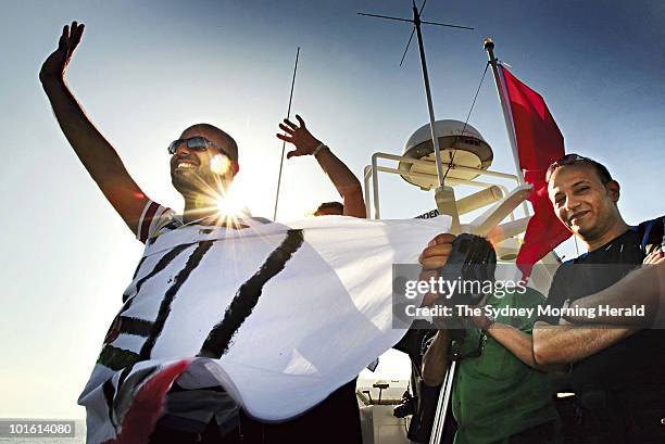 Nidal Hejazi from Palestine and Gehad Sakkur from Gaza, Palestine wave farewell on the "Amal" passenger boat as they set sail from Aghios Nikolaos as...