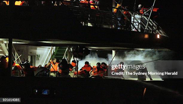 Passengers on the second deck of the Turkish passenger ship the Mavi Marmara run as they are surrounded by smoke from tear gas fired from Israeli...