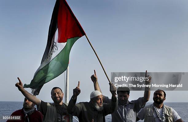 Unnamed passengers wave the Palestinian flag onboard the Turkish passenger ship Mavi Marmara as it heads to Gaza as part of the Freedom Flotilla on...