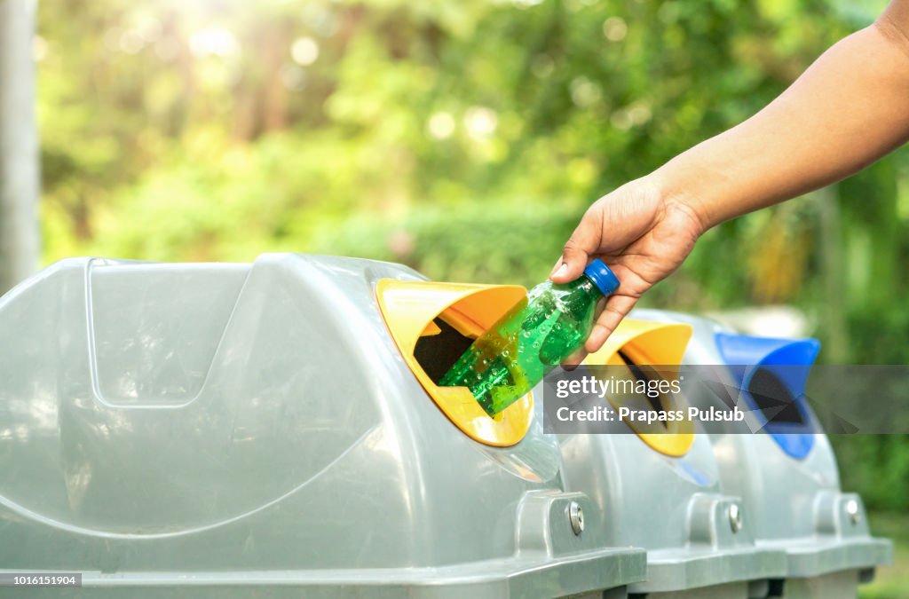 Close up hand throwing empty plastic bottle into the trash Recycling Concept