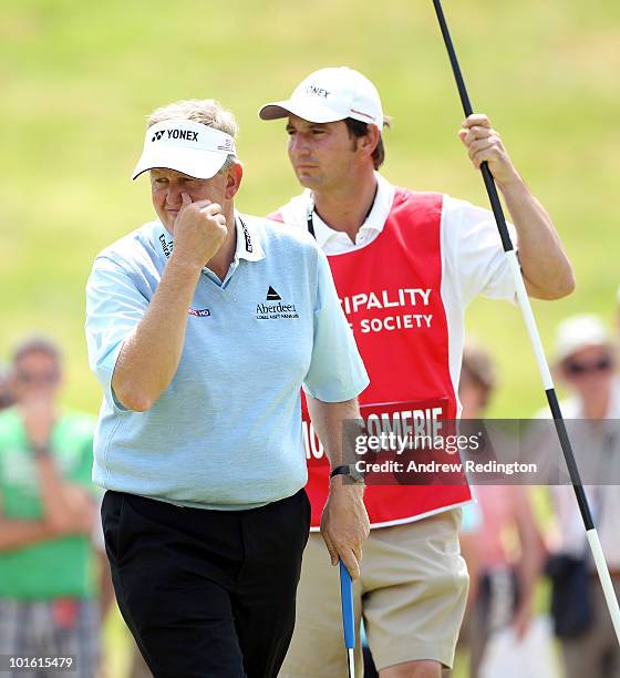 Colin Montgomerie of Scotland stands with his caddie Jason Hempelman on the first hole during the second round of the Celtic Manor Wales Open on The...