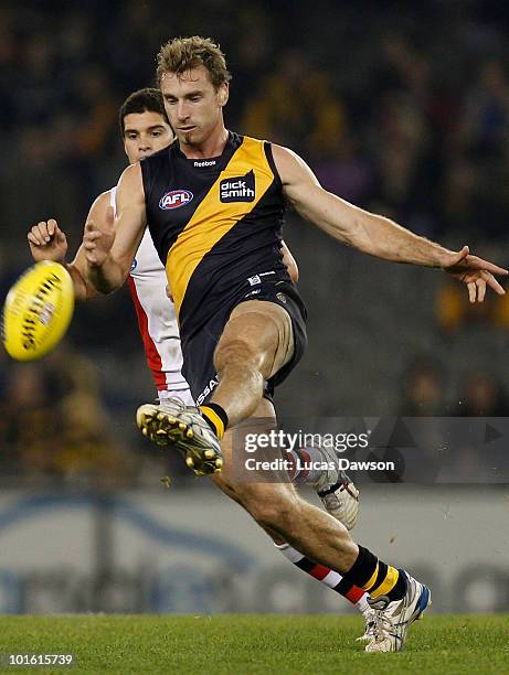 Shane Tuck of the Tigers kicks the ball during the round 11 AFL match between the Richmond Tigers and the St Kilda Saints at Etihad Stadium on June...