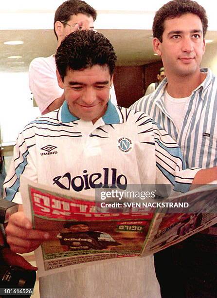 Argentinian soccer star Diego Maradona, in a Napoli shirt, reads the sports pages in an Israeli newspaper relating the arrival of the Argentinian...