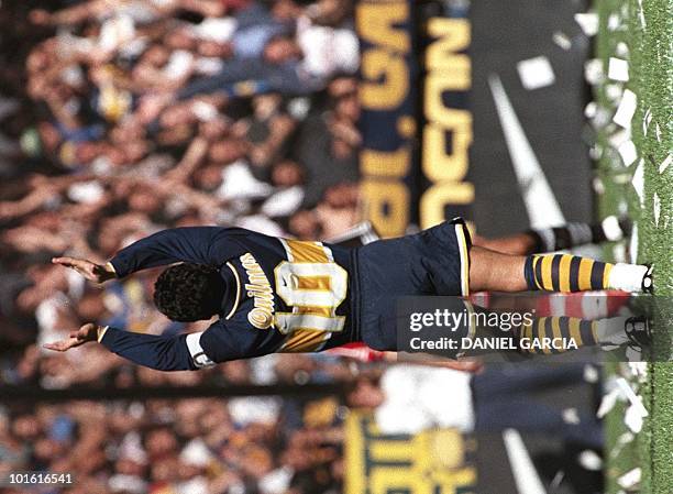 Argentine controversial soccer star Diego Maradona salutes the crowd 14 September before the start of the game in Buenos Aires between his Boca...