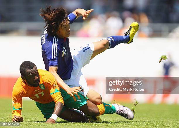Shunsuke Nakamura of Jaspan is tackled by Siaka Tiene of Ivory Coast during the Japan v Ivory Coast International Friendly match at Stade de...