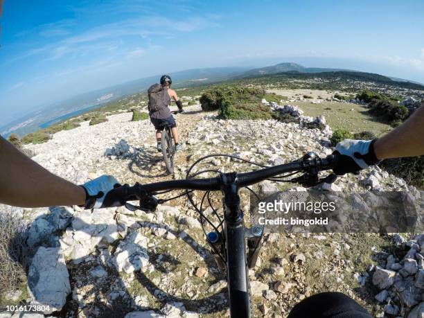 man and woman mountain biking above the sea point of view - 2 point perspective stock pictures, royalty-free photos & images