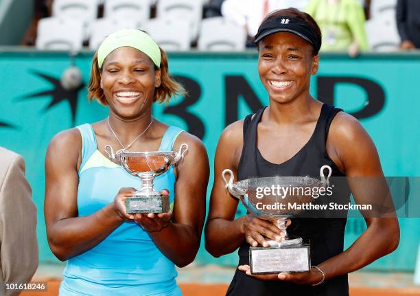 Serena Williams and Venus Williams of the United States pose with the trophy after winning the women's doubles final between Serena Williams and...