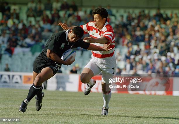 Ko Izawa tackles Alama Ieremia during the pool stage game between Japan and New Zealand at the 1995 Rugby World Cup, the Free State Stadium,...