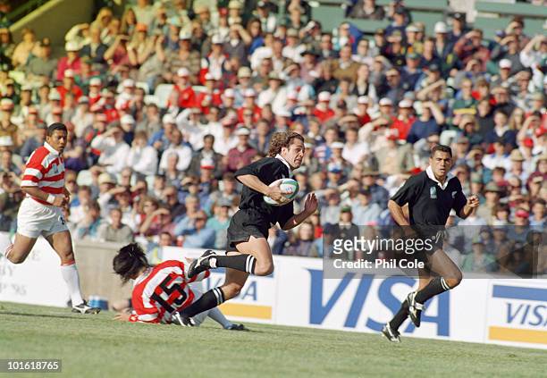 Marc Ellis escapes Tsutomu Matsuda during the pool stage game between Japan and New Zealand at the 1995 Rugby World Cup, Free State Stadium,...
