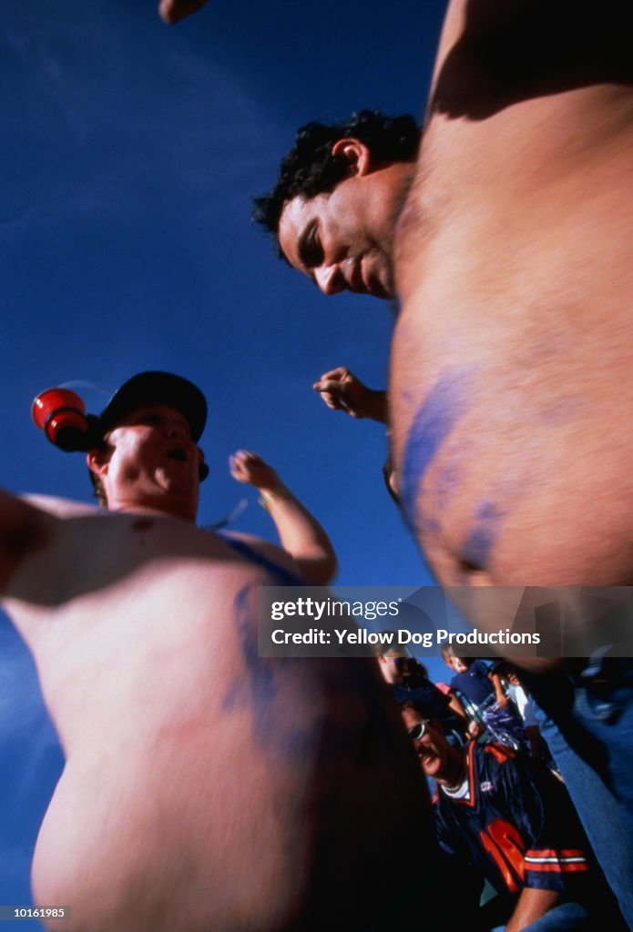 SPECTATORS IN STANDS AT A FOOTBALL GAME