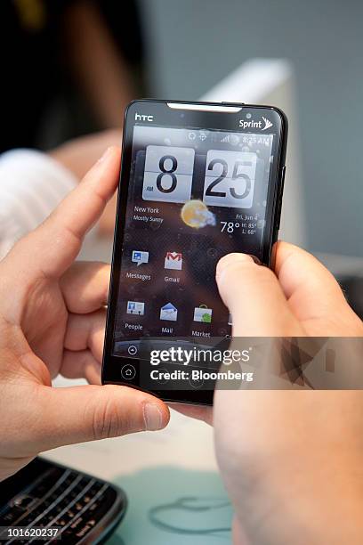 Shopper tries out the new HTC Corp. 4G Evo phone, which is powered by Google Inc.'s Android software, at a Sprint store in New York, U.S., on Friday,...