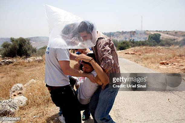 Palestinians evacuate a man after he inhaled tear gas near an Israeli barrier, as they object to Israel's attack on a Gaza aid flotilla earlier this...