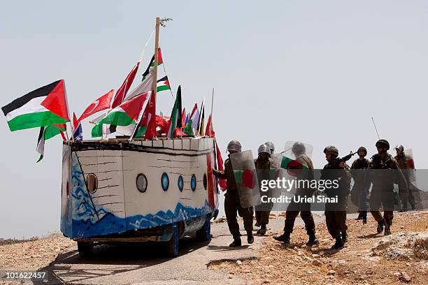 Israeli soldiers approach a replica of the Gaza aid flotilla used by Palestinians near an Israeli barrier, as they object to Israel's attack on the...