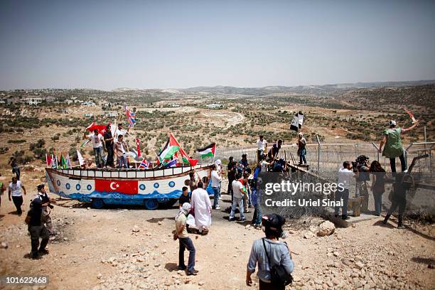 Palestinian protesters use a replica of the Gaza aid flotilla near an Israeli barrier, as they object to Israel's attack on the flotilla earlier this...