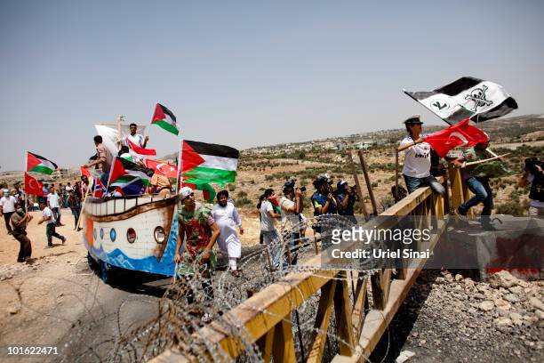 Palestinian protesters use a replica of the Gaza aid flotilla near an Israeli barrier, as they object to Israel's attack on the flotilla earlier this...