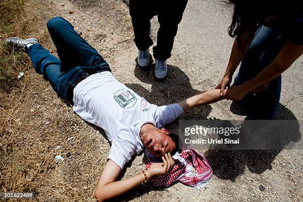 An unidentified Palestinian man lies on the ground after he inhaled tear gas near an Israeli barrier, against Israel's attack on a Gaza aid flotilla...