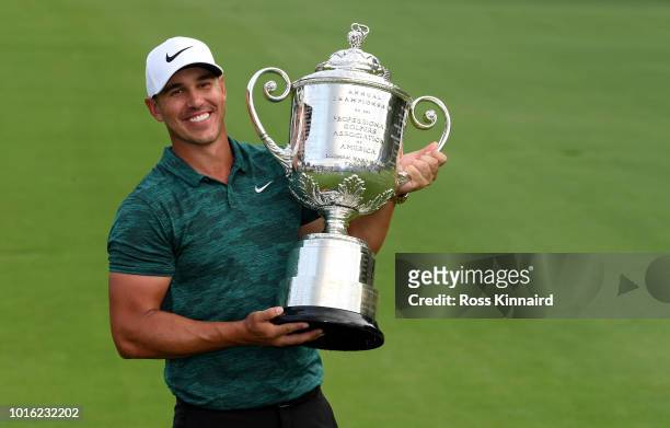 Brooks Koepka of the USA celebrates with the winners trophy on the 18th green after winning the 2018 PGA Championship at Bellerive Golf & Country...