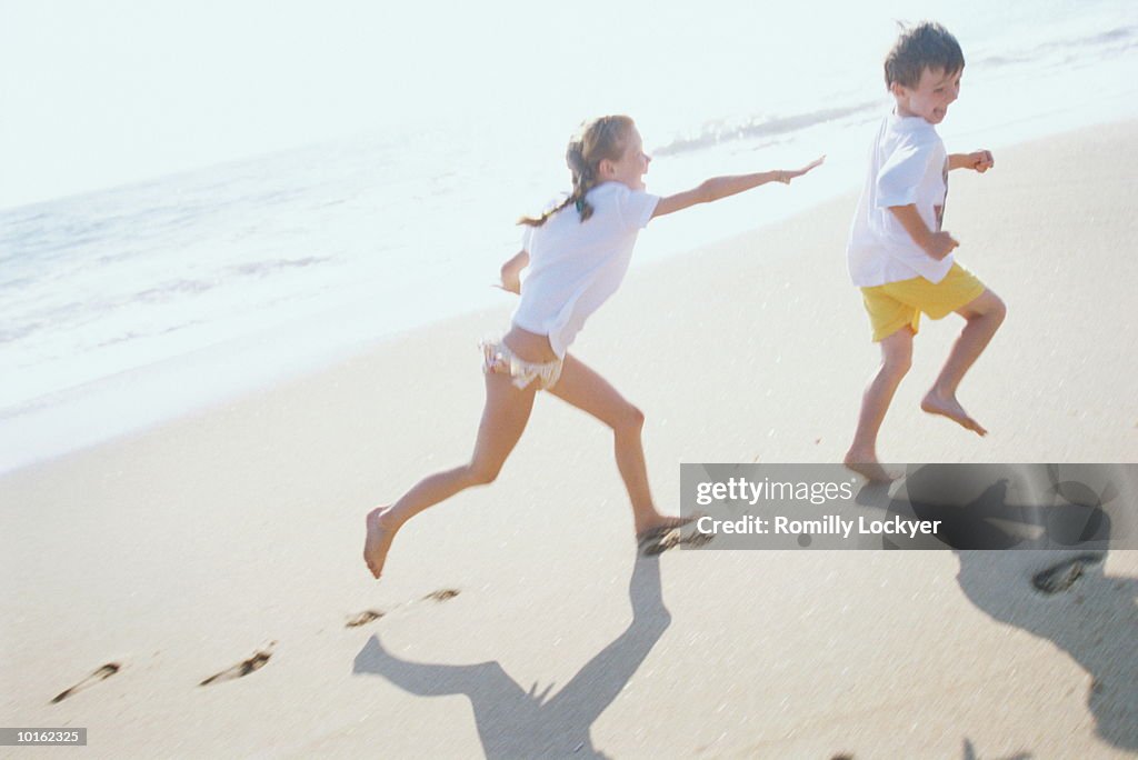 BOY PLAYING ON THE BEACH WITH WAVES