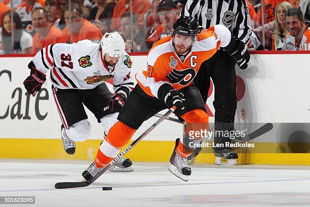 Mike Richards of the Philadelphia Flyers skates the puck in front of Adam Burish of the Chicago Blackhawks in Game Three of the 2010 NHL Stanley Cup...