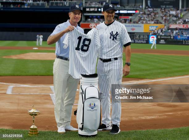 United States Ryder Cup Captain Jim Furyk and New York Yankees manager Aaron Boone exchange gifts prior to a game between the Yankees and the New...